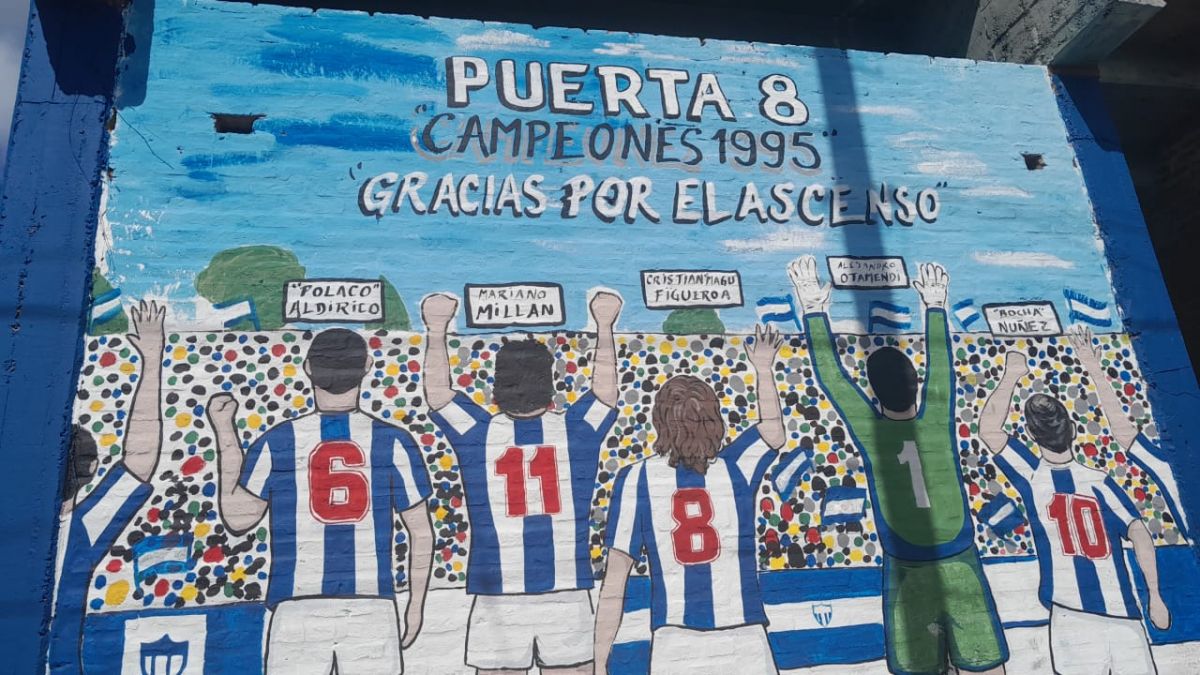 HOMENAJE. Un mural en la Puerta 8 recuerda a los protagonistas del ascenso de 1995 y celebra a aquella generación que llevó al club a Primera.