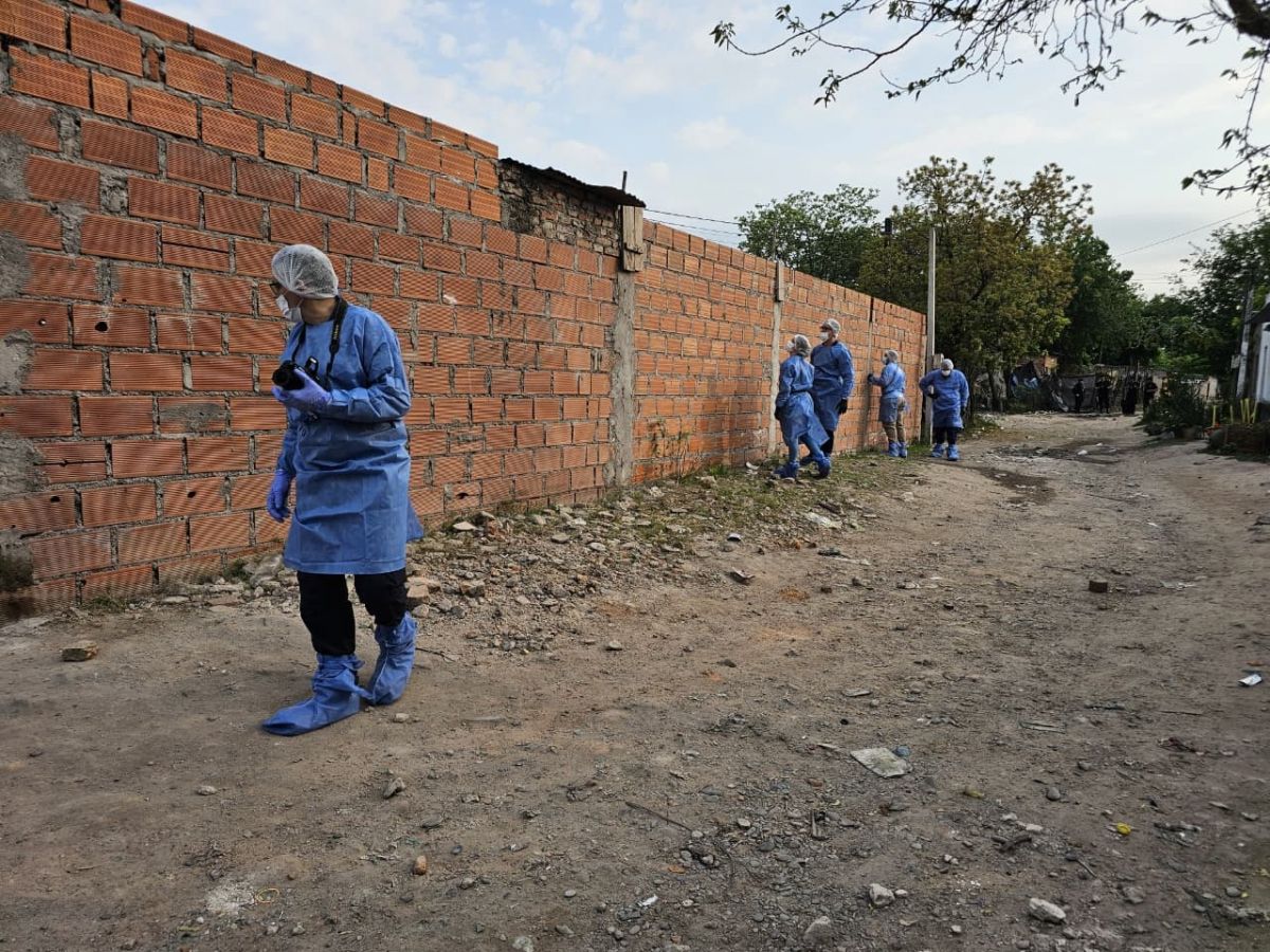 ANALIZANDO. Los investigadores buscan impactos de bala en las paredes de una casa del barrio 