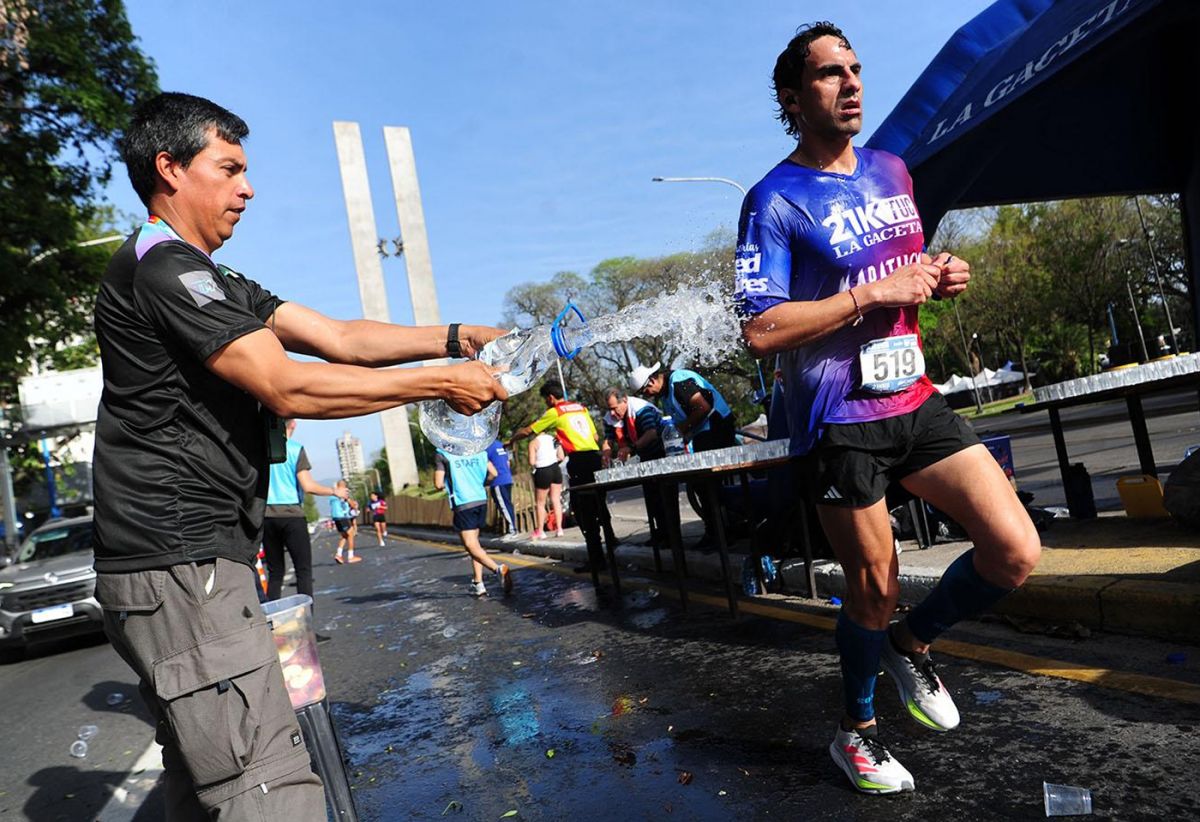 EN CARRERA. Un corredor atraviesa uno de los puestos de hidratación durante la edición pasada, con el Monumento al Bicentenario como parte del paisaje.