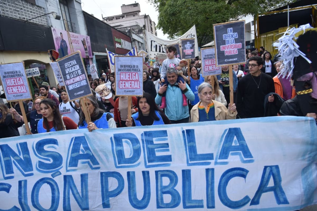 RECLAMO GREMIAL. Docentes universitarios marcharon con pancartas de ADIUNT para exigir la aplicación de la Ley de Financiamiento Universitario y reclamar una huelga general.