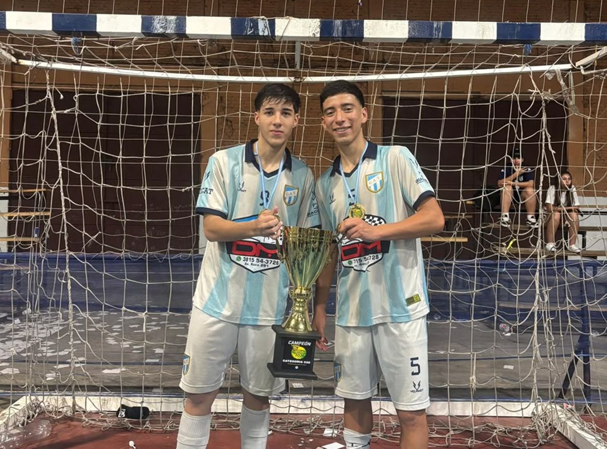 CAMPEONES. Gerónimo Morán y Santiago Zárate posan con el trofeo de la categoría C20, uno de los títulos que conquistaron con el futsal de Atlético antes de emigrar a Italia.