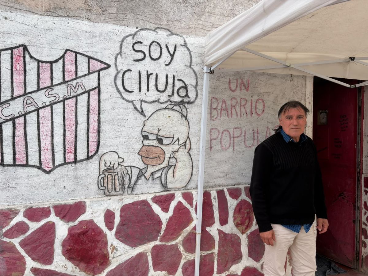 UN BARRIO POPULAR. Alberto Miranda, junto al mural de su negocio, confía en que el domingo la cancha se va a llenar.
